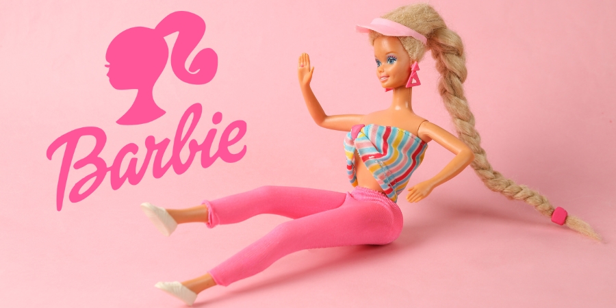 Barbie doll sitting next to Barbie logo