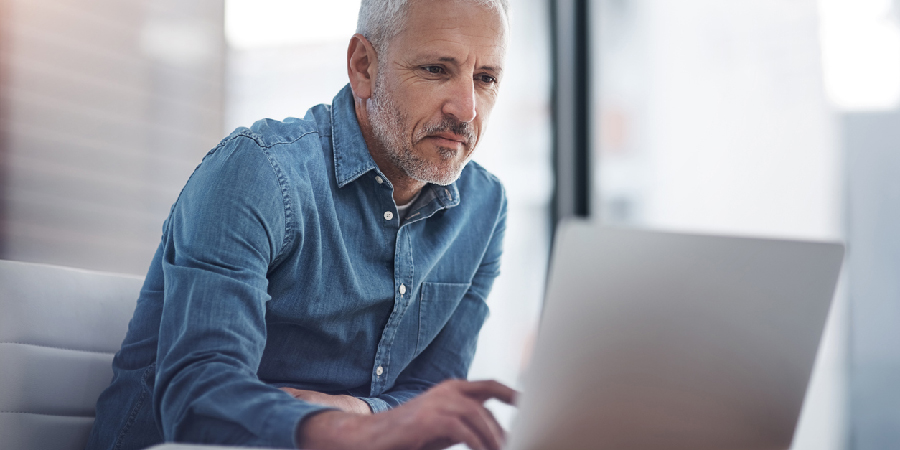 Cropped shot of a mature businessman working on a laptop in an office