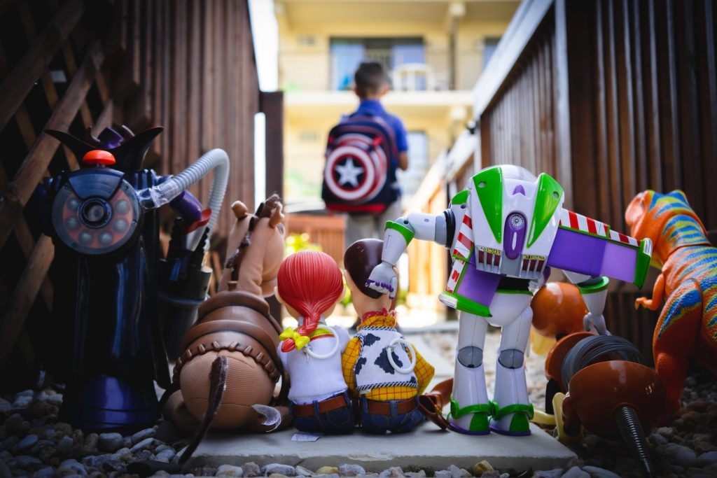 Boy standing with his back to a row of Toy Story toys