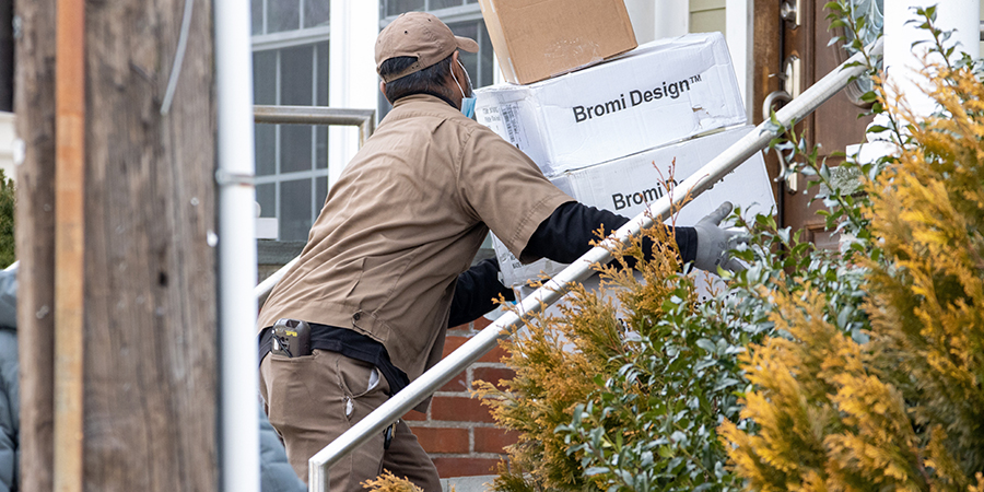 UPS worker going up stairs with packages in his arms